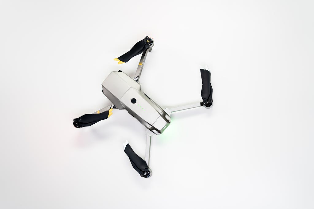 Overhead shot of a quadcopter drone with folded propellers on a clean white background.